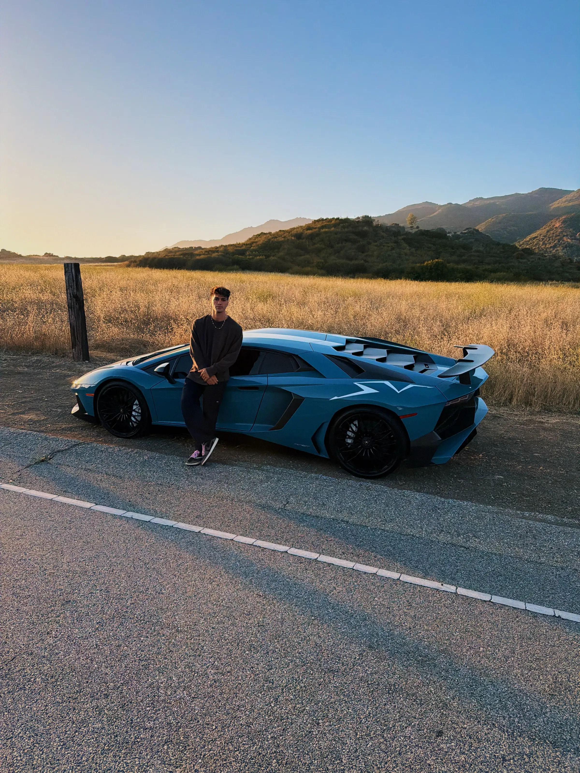 Thomas Petrou with one of his cars at golden hour