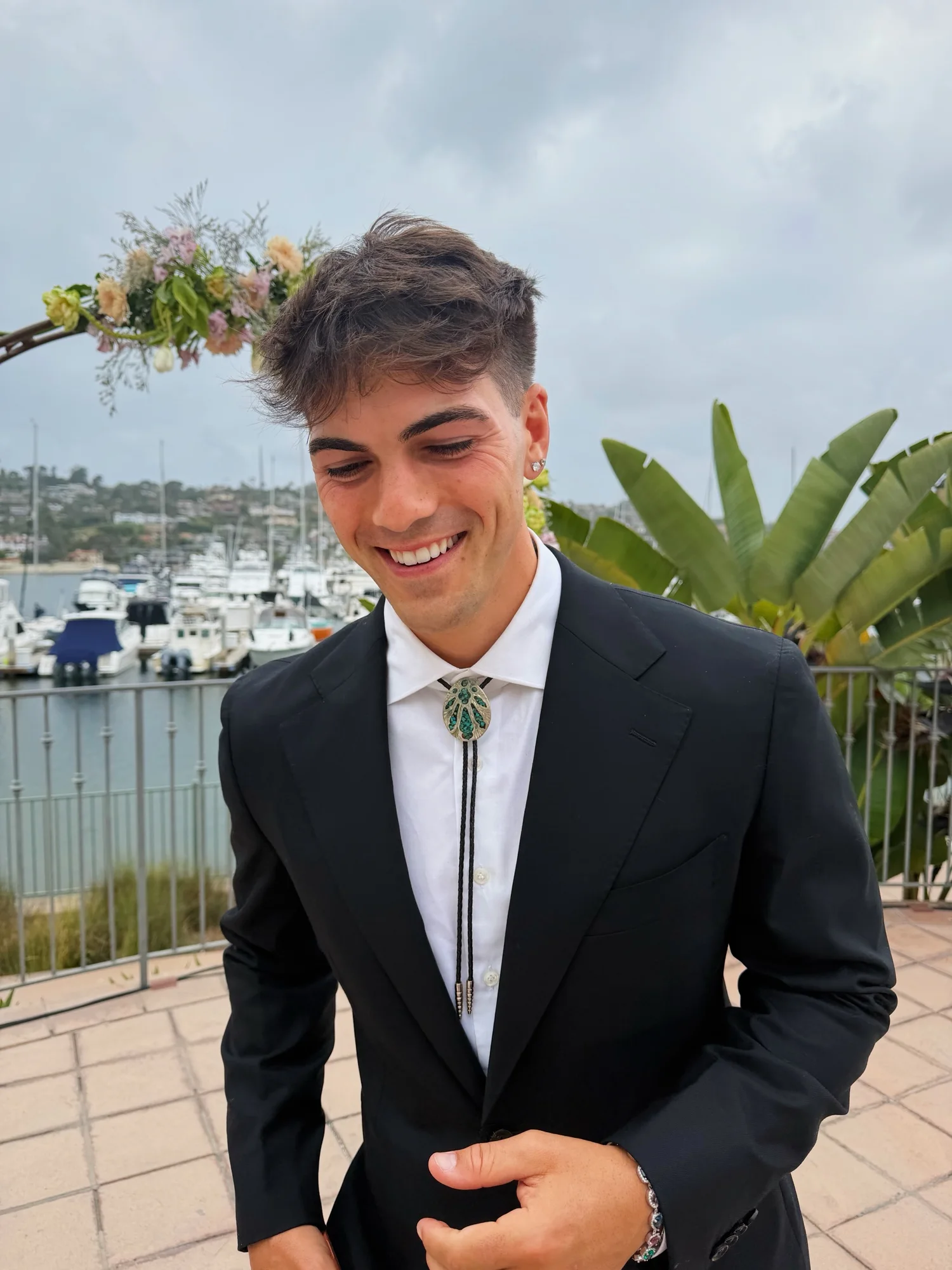 Thomas Petrou in a black suit and bolo tie, smiling